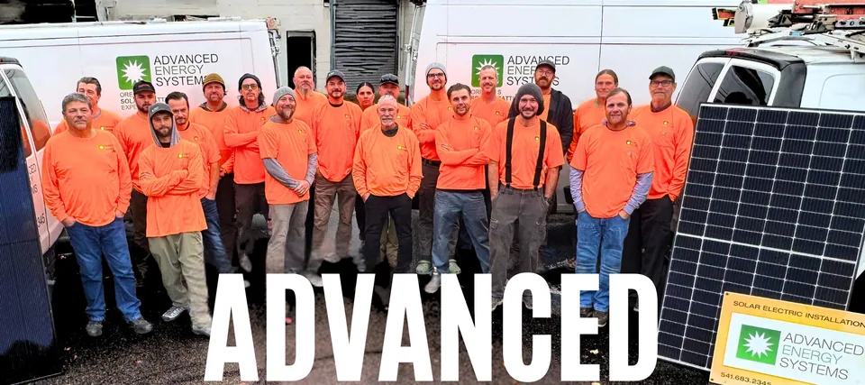 The Advanced Energy Systems crew in orange shirts beside a solar array