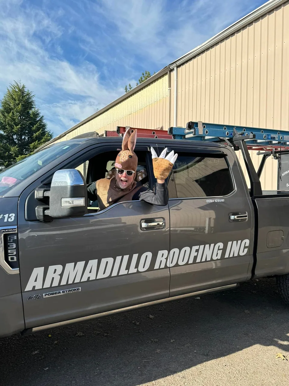 Armadillo Roofing truck with ladders on a job